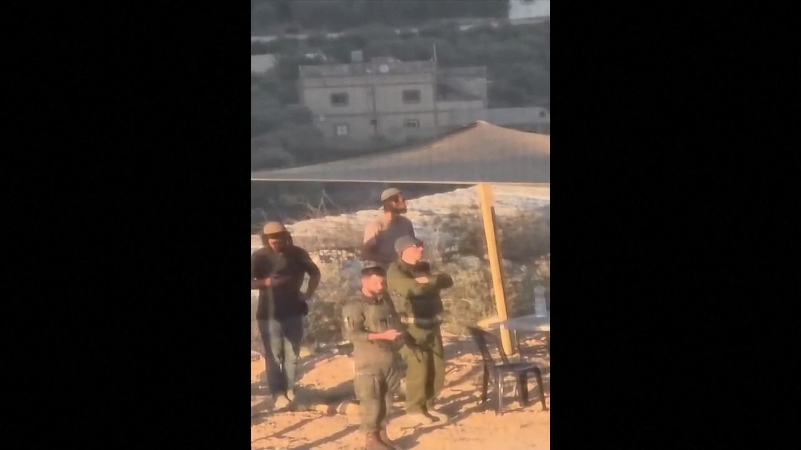 va colonos israelies rezan frenta a casa palestina sitiada